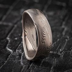 "* Price may vary depending on ring size, please inquire with us directly with your needed size for accurate pricing! This unique and quirky Mokume Gane ring is shown in the Twist pattern and Ash Palette, with a low dome profile, and an etched and oxidized finish. The band is made in a specialized undulating shape. The Ash palette features a combination of Palladium, and Sterling Silver.  Pattern: Twist Palette: Ash Finish: Etched and Oxidized Profile: Low Dome  Width Shown: 6.5mm Size Shown: 10.5 Price does NOT include stones or setting fees. We care about customer service and would like to hear from you! Please contact us to help create your treasured item, we take your concerns and requests to heart and will work together to create your unique designs SPECIAL PRICING FOR SETS. CONTACT U Modern Etched Rings, Unique Engraved Round Ring, Unique Carved Adjustable Rings, Artisan Carved Adjustable Ring, Mokume Gane Ring, Woodgrain Pattern, Quirky Wedding, Twist Pattern, Mokume Gane