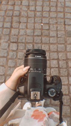 a person holding up a camera on the street