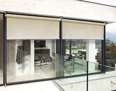 an outside view of a house with glass walls and sliding doors leading to the bedroom