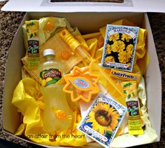 an open box with sunflowers, soap and other items in it sitting on the floor