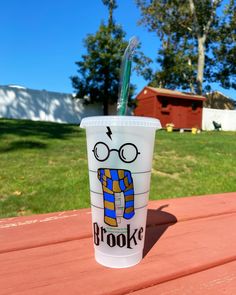 a plastic cup with a straw sticking out of it's side on a picnic table