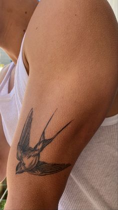 a man with a bird tattoo on his arm