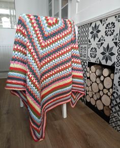 there is a crocheted blanket next to a fireplace