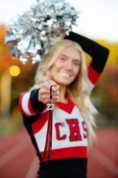 a cheerleader is posing for the camera with her pom - pom hat