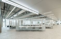 an empty office with chairs and tables in the middle of the room, all white