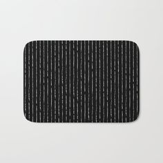 a black and white striped bath mat on a white background with vertical lines in the center