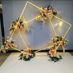 an arrangement of flowers arranged in a hexagonal frame on a white table cloth