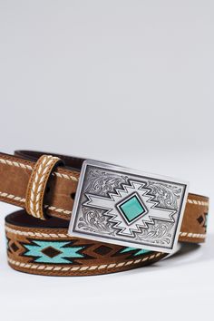 This ladies Ariat belt by M&F Western Products is so stylish. Genuine leather with white buck lace stitching that runs the outer edge of the belt. The inlay is designed with an embroidered turquoise pattern. Will go with a variety of styles and looks. Sizing Guide: Ariat belts are measured from the end of the strap on the buckle side to the center of the middle hole. The best rule of thumb is to buy a belt 2” larger than your waist/pant size. Small: 30” Medium: 34” Large: 38” XLarge: 42” Small Western Belts, Womens Western Belts, Country Belts For Women, Western Belts For Women, Cowgirl Belt Buckles, Ariat Belts, Texas Belt Buckle, Country Belts, Turquoise Belt Buckle