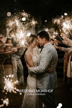 a bride and groom are surrounded by sparklers