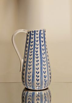 a blue and white pitcher sitting on top of a table