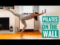 a woman doing yoga in front of a fire place with the words pilates on the wall above her