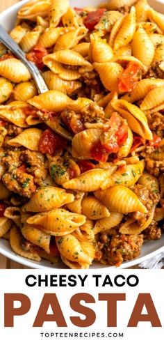 a bowl full of cheesy taco pasta with meat and tomatoes on top