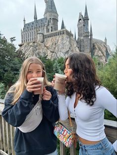 two girls drinking coffee in front of hogwarts castle