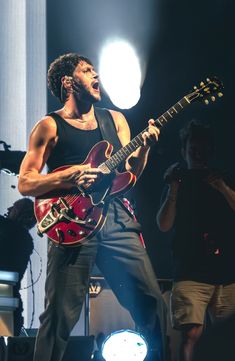 a man with an electric guitar on stage