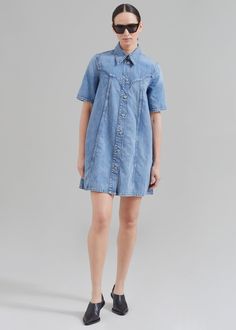 Color: Mid Blue Vintage Midweight denim Relaxed fit A-line silhouette Mini length Pointed collar Short sleeves Side seam hip pockets Ganni logo blue metal buttons Front button closure Unlined 100% Organic Cotton Cold Machine Wash By GANNI. Made in Turkey Light Wash Collared Denim Dress, Denim Blue Relaxed Fit Denim Dress With Button Closure, Denim Shirt Dress With Short Sleeves In Medium Wash, Relaxed Fit Denim Blue Denim Dress With Button Closure, Light Wash Denim Dress With Collar, Relaxed Fit Dark Wash Denim Dress With Button Closure, Relaxed Fit Knee-length Denim Dress With Buttons, Relaxed Fit Mini Denim Dress For Work, Knee-length Denim Dress With Buttons In Relaxed Fit