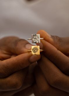 a person holding two rings in their hands with the other hand on top of them