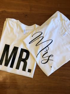 two t - shirts with the words mr and mrs on them sitting on a wooden floor