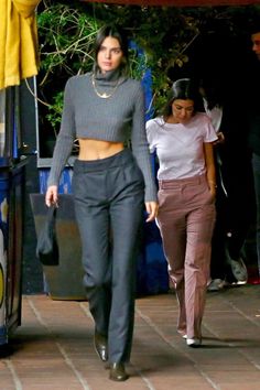 two women walking down a sidewalk next to each other