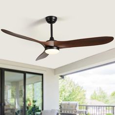 a ceiling fan that is on the outside of a house with patio furniture in the background