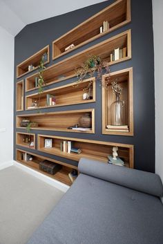 a living room with bookshelves and shelves on the wall next to a couch