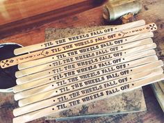 several pieces of metal sitting on top of a wooden table next to some hammers