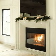 a fireplace with candles and garland on it