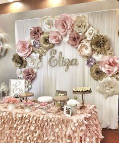 a table topped with cakes and desserts under a flower covered backdrop that says blyja