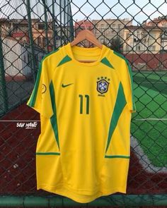 a yellow soccer jersey hanging on a fence