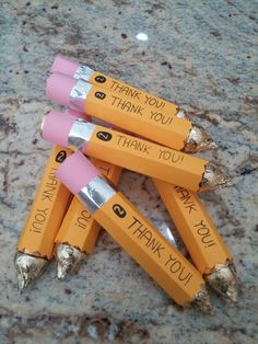 four orange pencils with writing on them sitting on a granite counter next to each other