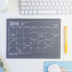 a desk with a calendar, keyboard and other office supplies on it's surface