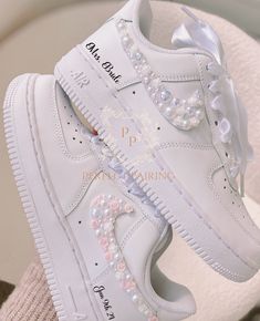 a pair of white sneakers with pearls on them