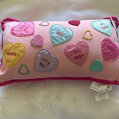 a pink pillow with embroidered hearts on it