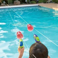 a boy is playing with water toys in the pool