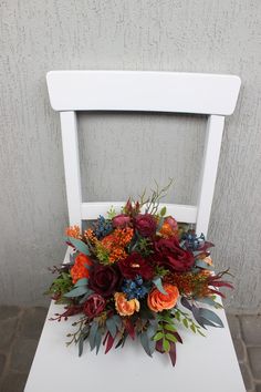 a bouquet of flowers sitting on top of a white chair