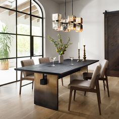 a dining room table with chairs and vases on it