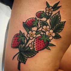 a woman's thigh with flowers and strawberries on it