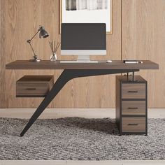 a desk with a computer on it in front of a wood paneled wall and rug