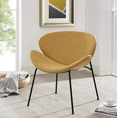 a yellow chair sitting on top of a hard wood floor next to a white wall