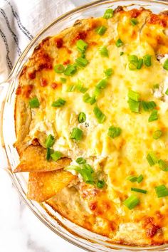 a cheesy dish with tortilla chips and green onions