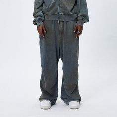 The Distressed Crinkled Baggy Sweatpants are a unique fusion of relaxed style and textured design. These sweatpants showcase a stonewashed, distressed look, creating a vintage and worn-in appeal that is both fashionable and comfortable. A distinctive feature of these pants is the double crinkled design strategically placed on both the inner and outer sides of the legs, adding an interesting visual and tactile element to the garment. The oversized silhouette of the pants offers a contemporary, re Grunge Washed Pants For Streetwear, Faded Baggy Grunge Pants, Cotton Stonewashed Washed Black Bottoms, Washed Black Stonewashed Cotton Bottoms, Stonewashed Washed Black Cotton Bottoms, Stonewashed Cotton Bottoms In Washed Black, Baggy Distressed Pants For Streetwear, Faded Baggy Pants For Streetwear, Baggy Distressed Washed Black Pants