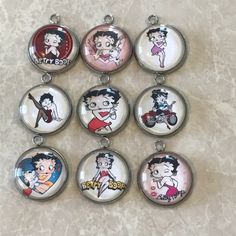 six keychains with cartoon characters on them sitting on a marble counter top in front of a white background