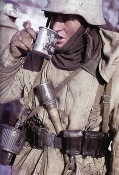 a man in uniform drinking from a cup