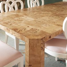 a wooden table with white chairs around it