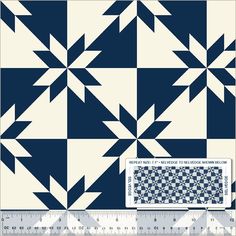 a blue and white quilt with an arrow pattern on the front, next to a ruler