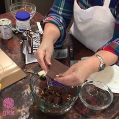 a woman is scooping chocolate into a bowl on the counter with other ingredients around her