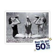 three women in bathing suits sitting on the ground with their hands up to their heads