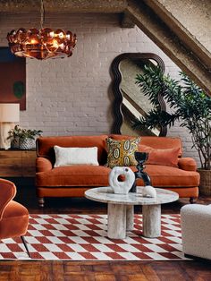 a living room filled with furniture and a chandelier hanging over the top of it