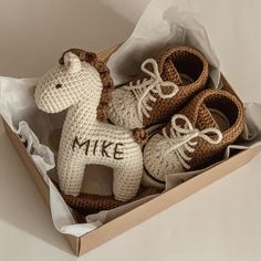 two crocheted shoes in a box with the word mike on them and a horse