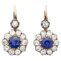 Exceptional stones meet classic design in these beautiful sapphire and diamond drop earrings. Made of 18 karat gold, at the center of each of these gorgeous earrings is a fine round vibrant blue sapphire weighing 0.80 carats (1.60cttw) surrounded by a halo of fine white natural old cut diamonds and a single diamond suspended above each halo, for a total diamond weight of 1.65 carats. The earrings hang just under 1.0" long and weigh 4.1 grams total, while the old cut diamonds average G-H color and VS2-SI1 clarity, delivering more than enough sparkle! Treat yourself or someone you love to some ear candy! Gold Flapper, Yellow Gold Drop Earrings, Blink Blink, Vintage Drop Earrings, Sapphire And Diamond Earrings, White Gold Sapphire, Diamond Dangle Earrings, Long Dangle Earrings, Pear Shaped Diamond