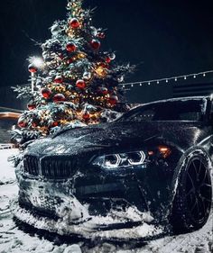 a black car parked in front of a christmas tree